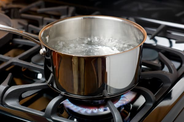 A pot of water boiling on a gas burner